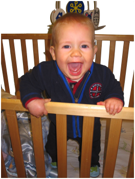 Happy baby smiling in crib.